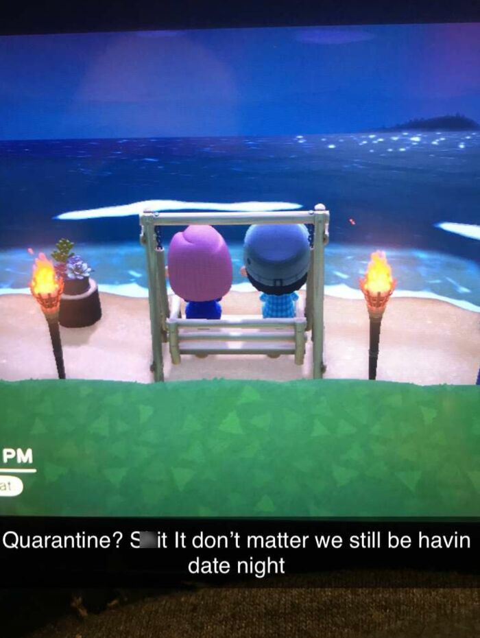 A screenshot from a video game showing two Animal Crossing characters sitting on a swing by the beach, a wholesome image.