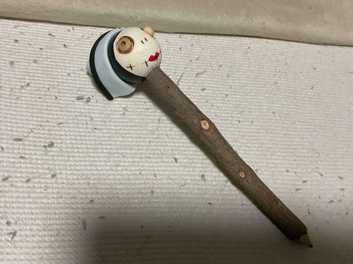 A baffling image of a unique wooden pen with a doll-like head, prompting questions from internet users.
