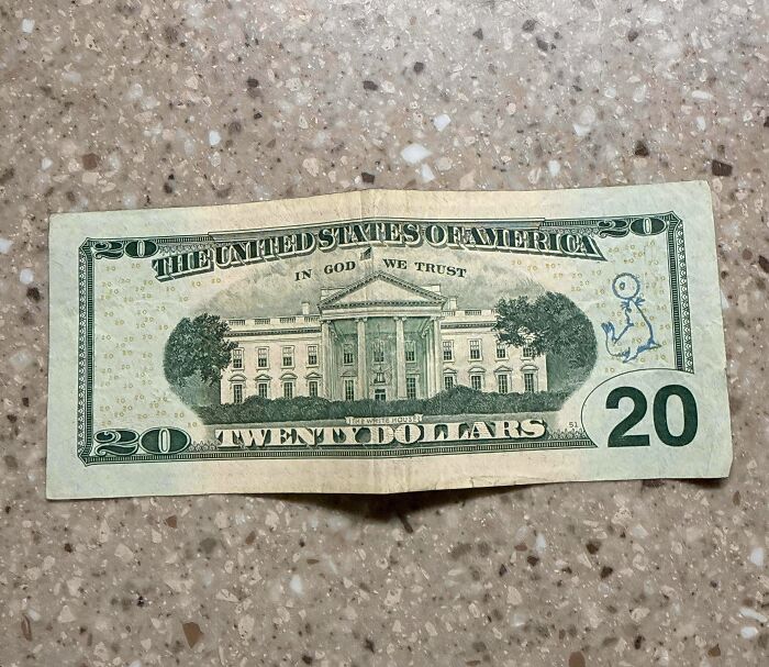 A baffling image of a twenty-dollar bill with a small, whimsical alien drawing on the back.