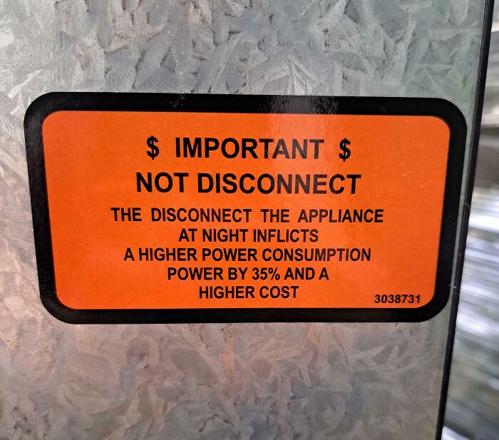 A baffling image of a badly translated orange warning sticker about appliance power consumption.