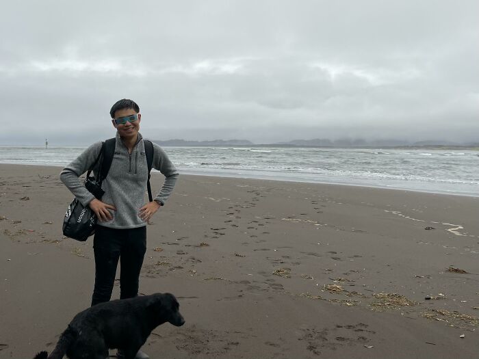 A man with a dog on a cloudy beach, highlighting trips that didn't go as planned.