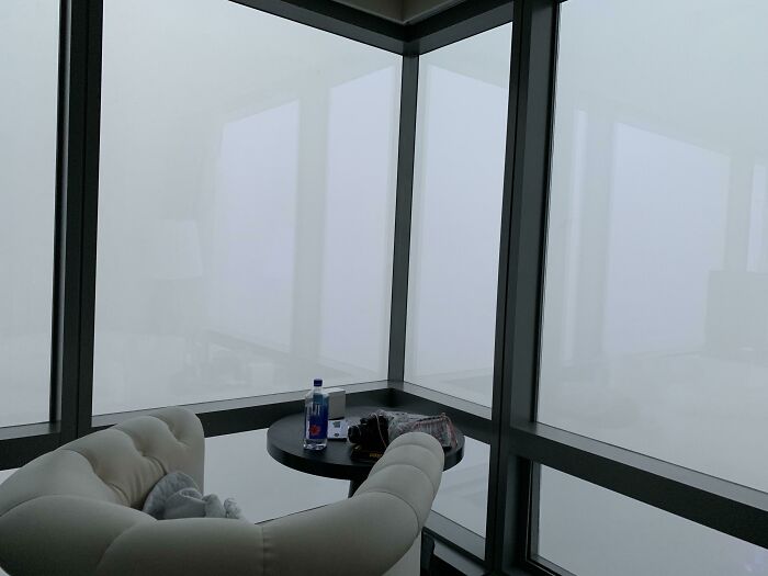 A hotel room with opaque windows due to fog, showing a trip not going as planned.