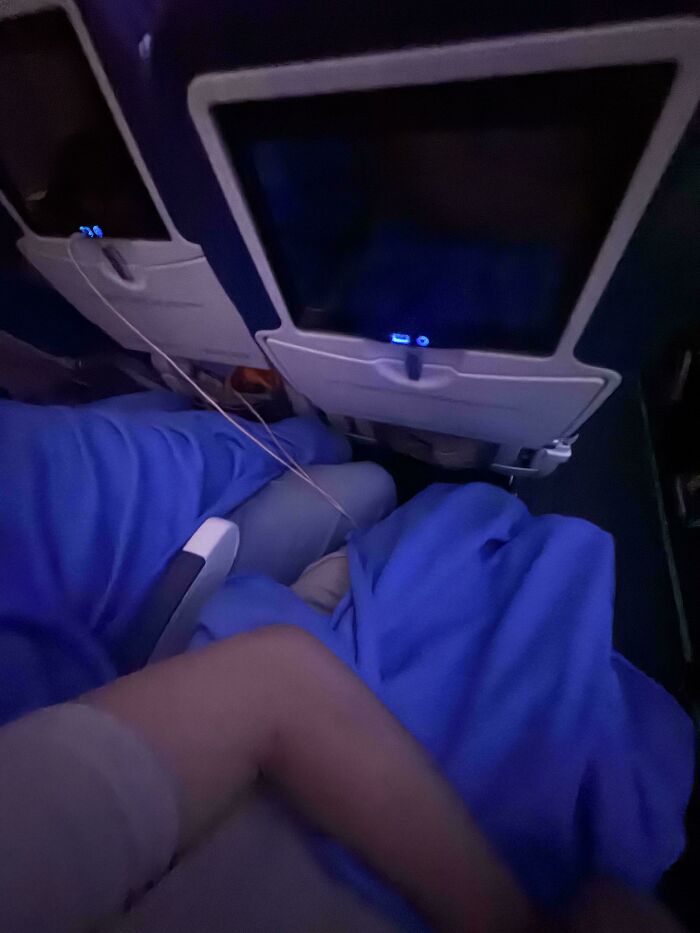 An airplane passenger stretching out on multiple seats, embodying entitled folks who ignore others. This image shows a moment of entitlement.