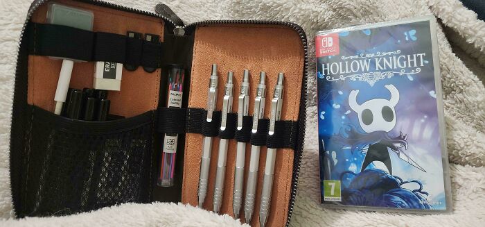 A collection of drawing pencils and a Hollow Knight game, unrelated to entitled folks but showing personal items.