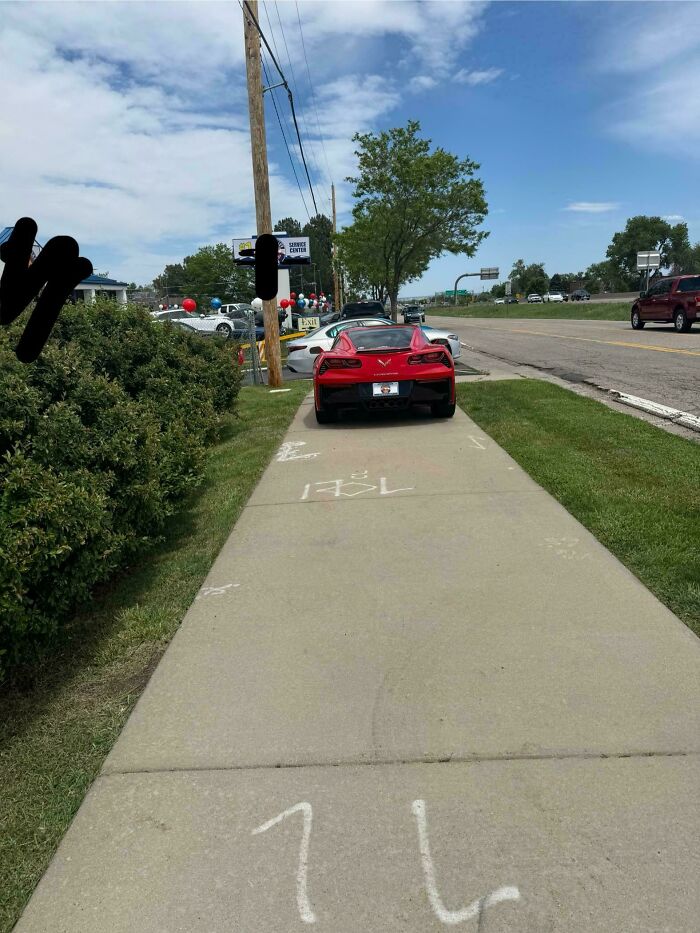 Red sports car parked obstructively on a sidewalk, exemplifying entitled folks who ignore rules for others.