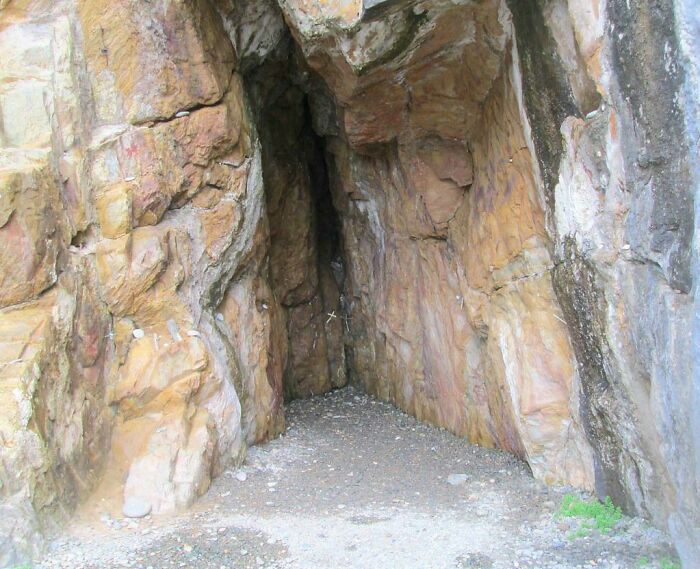 A dark cave entrance in a rocky cliff, showing a trip that didn't go as planned.