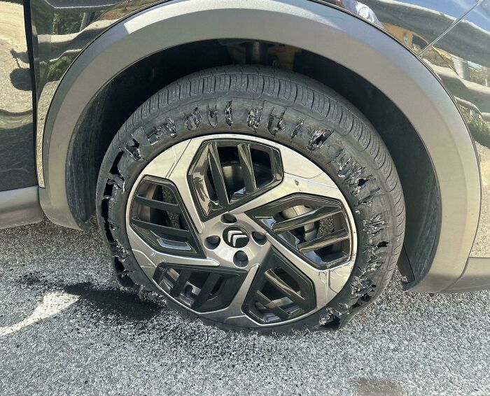 A severely damaged car tire with shredded rubber, indicating a trip that didn't go exactly as planned.
