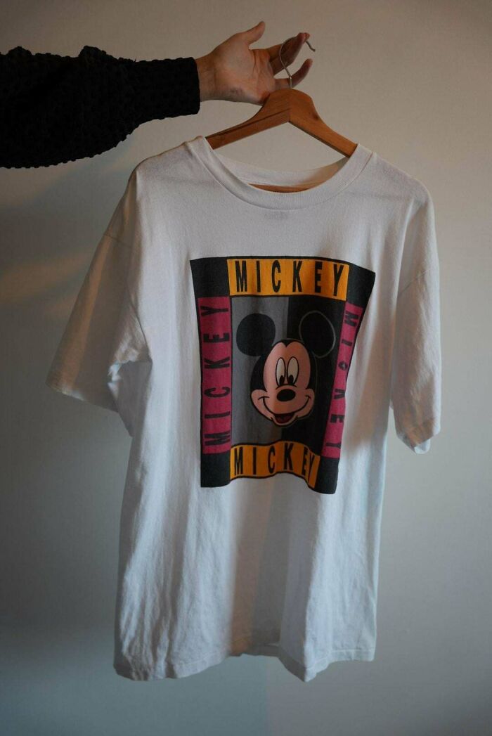 College life: A hand holding up a Mickey Mouse t-shirt, symbolizing the complete freedom of personal expression in a new world.