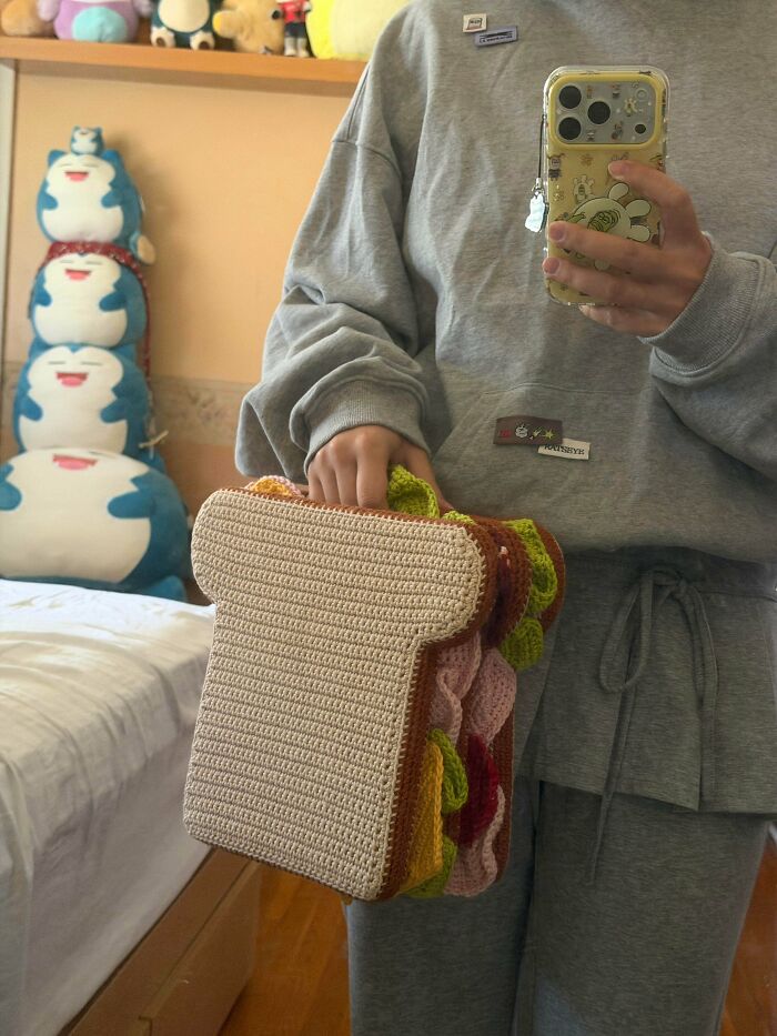 Handmade crochet sandwich shaped handbag held by person
