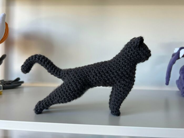 Crochet black cat figurine standing on a shelf