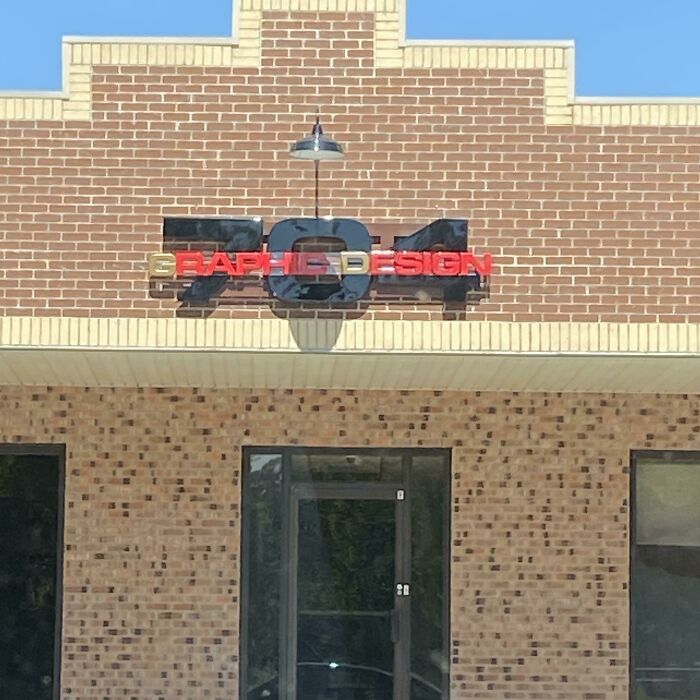 A building with the sign 704 GRAPHIC DESIGN showing a clear design fail.