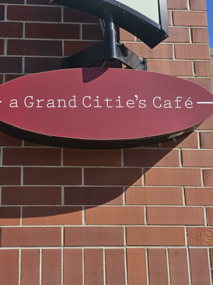 A red oval sign for a Grand Citie's Café, an impressive design fail in the spelling.