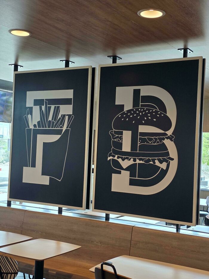 Restaurant wall art with a funny design fail, the number 73 with a burger and fries as part of its design.