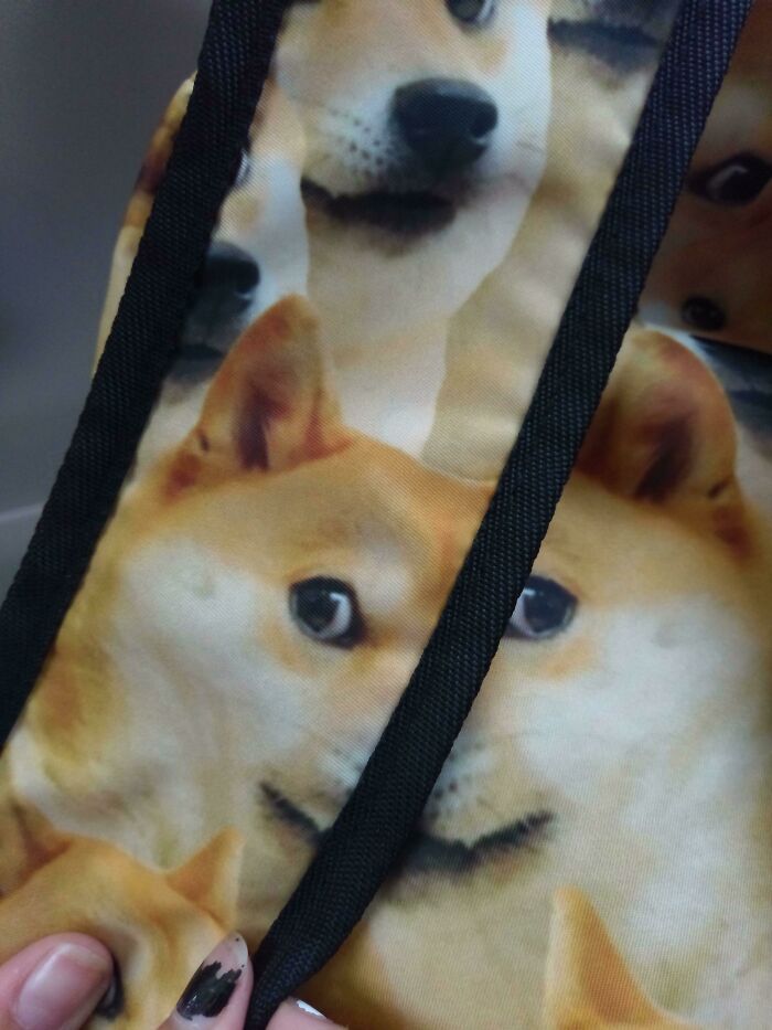 Doge meme pattern on fabric with a strap obscuring the faces, an amusing design fail.