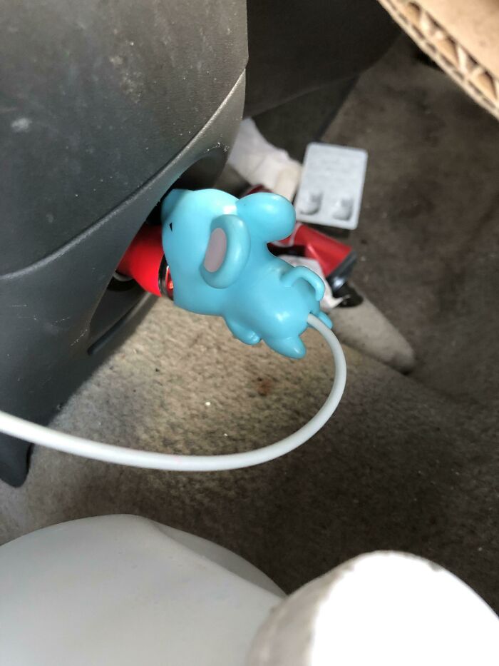 A blue elephant-shaped car charger design fails plugged into an outlet, with a white cable extending.