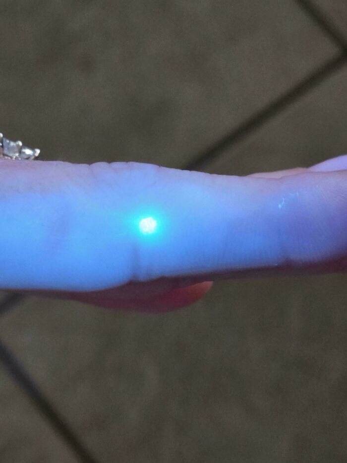 A bright glowing light on a person's finger, an interesting and unexpected moment.