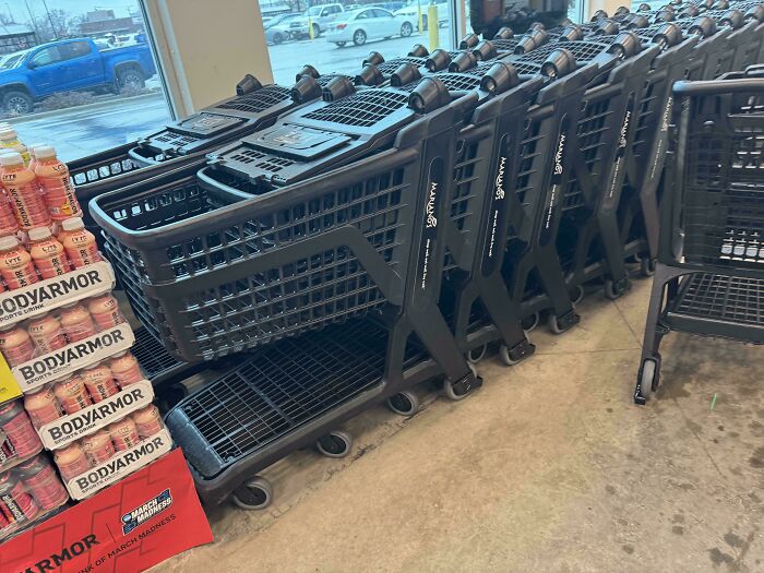 A row of black shopping carts in a store, a weird and unexpected moment of uniformity.