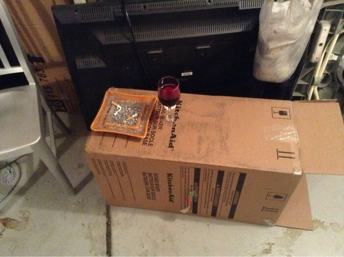 A hilariously bad DIY example with a glass of red wine and an ashtray on a cardboard box.