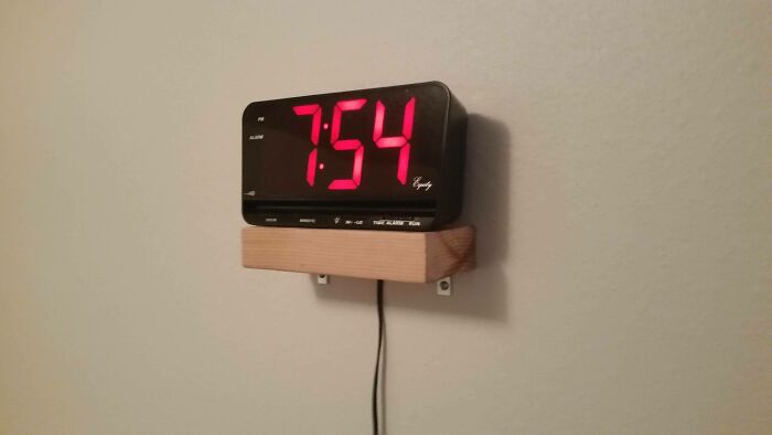 Hilariously bad DIY example: an alarm clock on a small, poorly mounted wooden shelf.