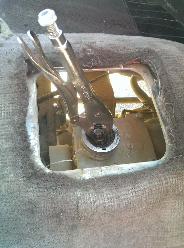 Hilariously bad DIY example: a wrench used as a gear shift in a dusty car interior.
