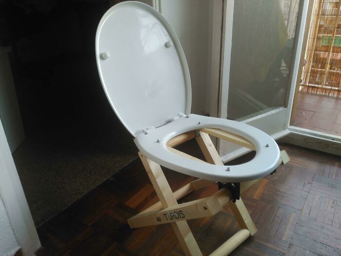 Hilariously bad DIY example: A toilet seat precariously perched on a foldable wooden frame.