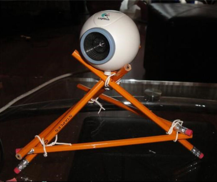 A webcam on a tripod made of pencils, a hilariously bad example of DIY.