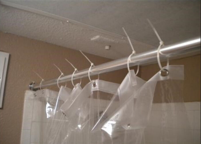 A shower curtain held up by zip ties instead of proper rings, a hilariously bad example of DIY.