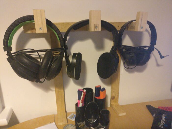 Hilariously bad DIY headphone rack made from raw wood blocks screwed into the wall.
