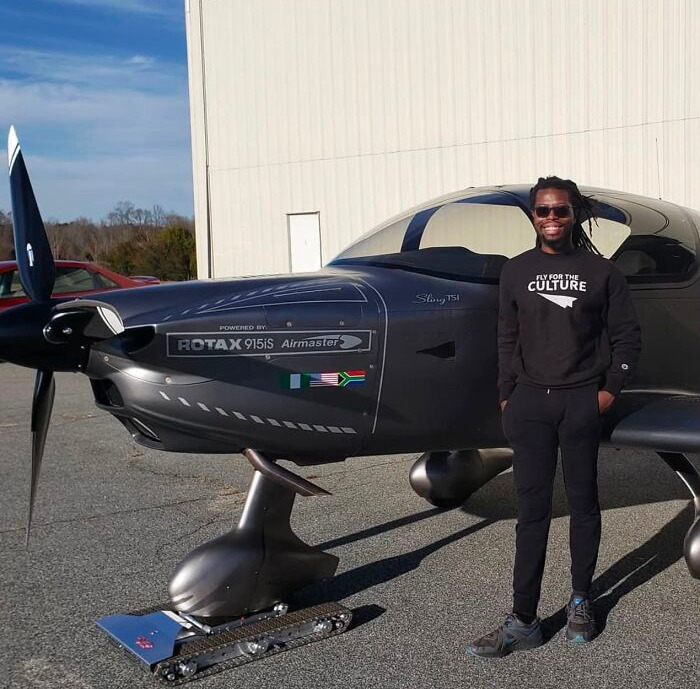 A man stands proudly by his private plane, marking incredible accomplishments.
