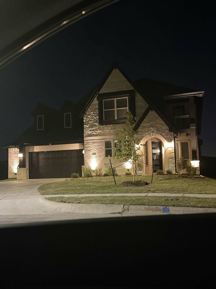 A beautiful modern house illuminated at night, representing the incredible accomplishment of homeownership.