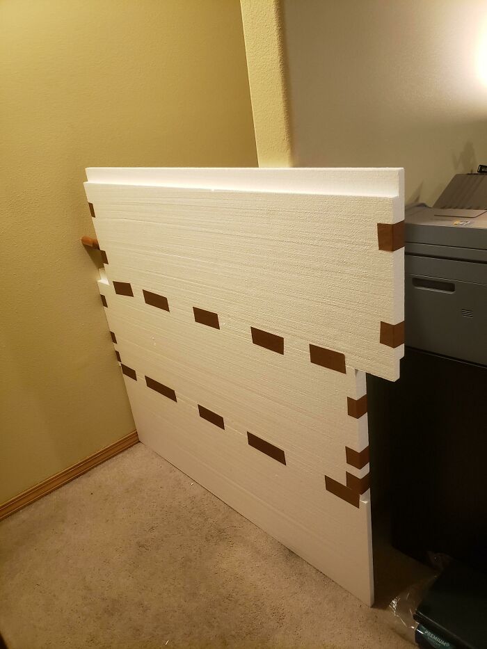 Hilariously bad DIY insulation made from white foam boards taped together, leaning against a wall.