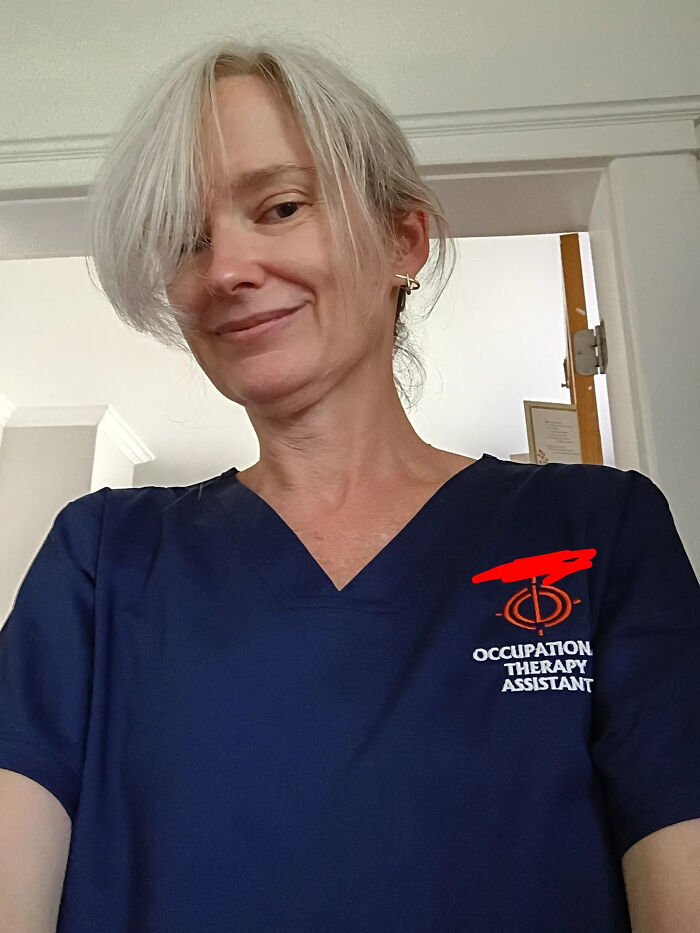 A woman wearing an Occupation Therapy Assistant scrub top, representing incredible accomplishments.