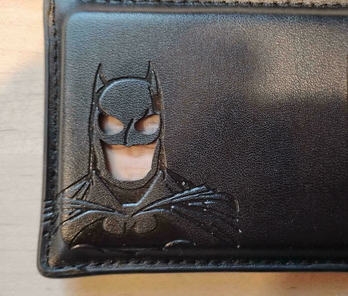 A close-up of a black wallet with an embossed Batman logo, representing a weird and unexpected moment.