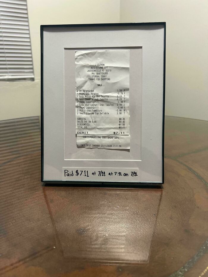 A framed 7-Eleven receipt showing a total of $7.11 paid at 7:11, an interesting and unexpected moment of coincidence.