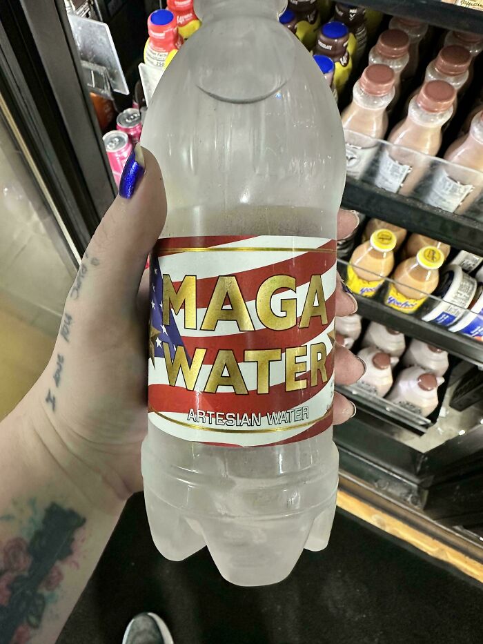 A person holding a bottle of MAGA water in a convenience store, a weird and unexpected product.