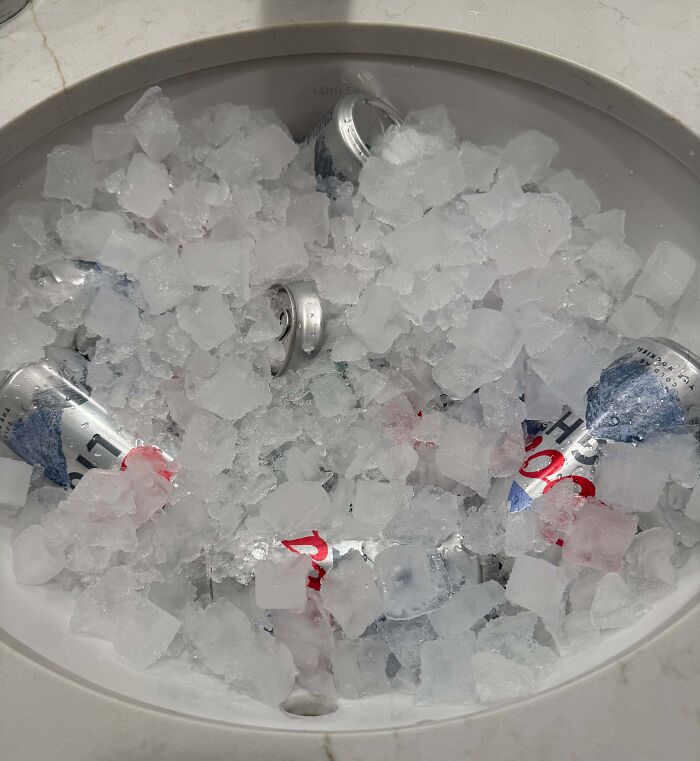 Beer cans chilling in a sink full of ice, an example of clever solutions.