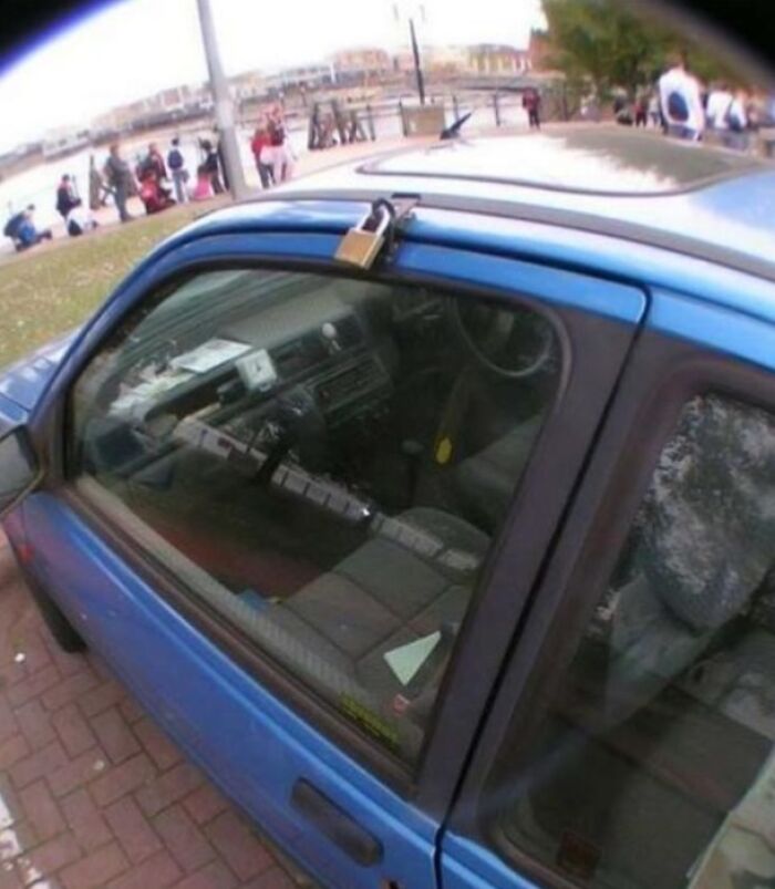 A hilariously bad DIY example of a car with a padlock securing the sunroof, illustrating a poor attempt to fix it.