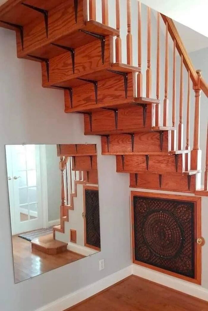 A hilariously bad DIY example: wooden stairs with mismatched supports and a mirror reflecting more stairs.