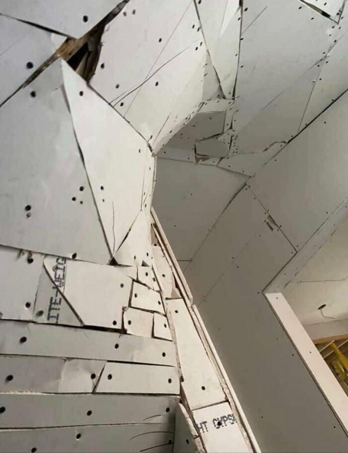 Hilariously bad DIY drywall installation with many small, irregularly cut pieces patched together on walls and ceiling.
