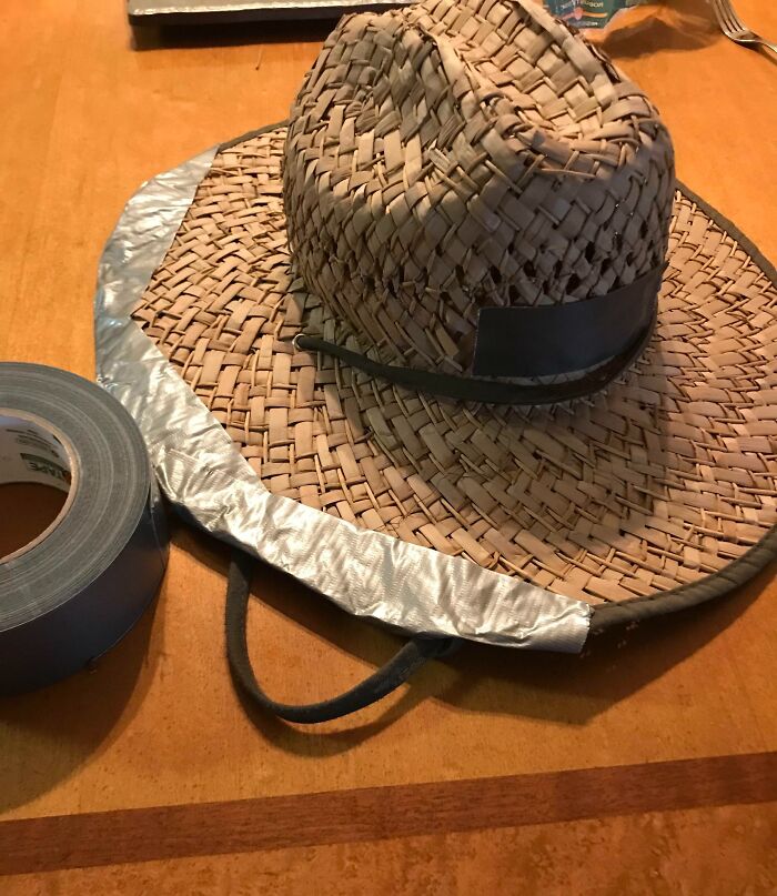 A straw hat with duct tape on its brim, a hilariously bad example of DIY