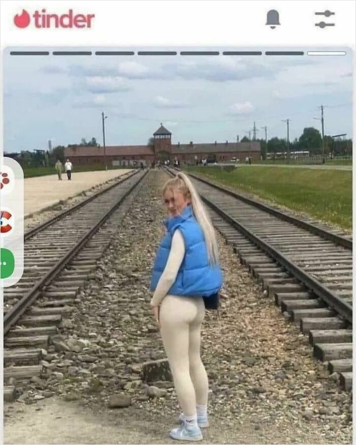 A woman posing on train tracks in front of the Auschwitz gate, an example of entitled folks.