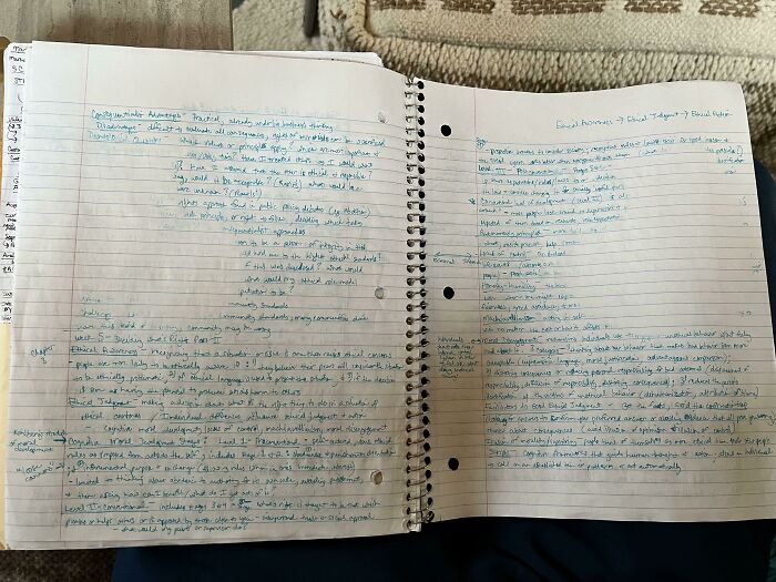 An open spiral notebook filled with handwritten notes and doodles, a mildly infuriating obstacle for tidiness.