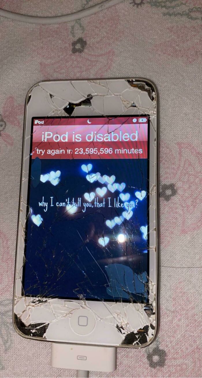 A severely cracked iPod with a disabled screen showing a long countdown, an infuriating obstacle.