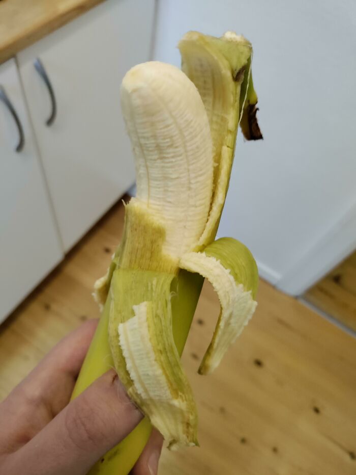 A partially peeled banana, showcasing a mildly infuriating obstacle.