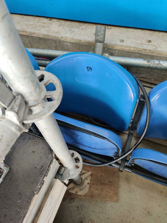 A mildly infuriating obstacle: A blue stadium seat numbered 59, with a metal pole obstructs the view.