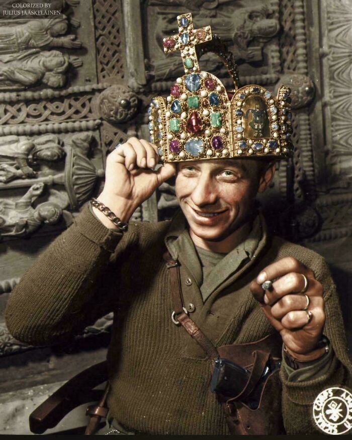 A smiling American soldier trying on a jeweled crown, a rare photo from American history.