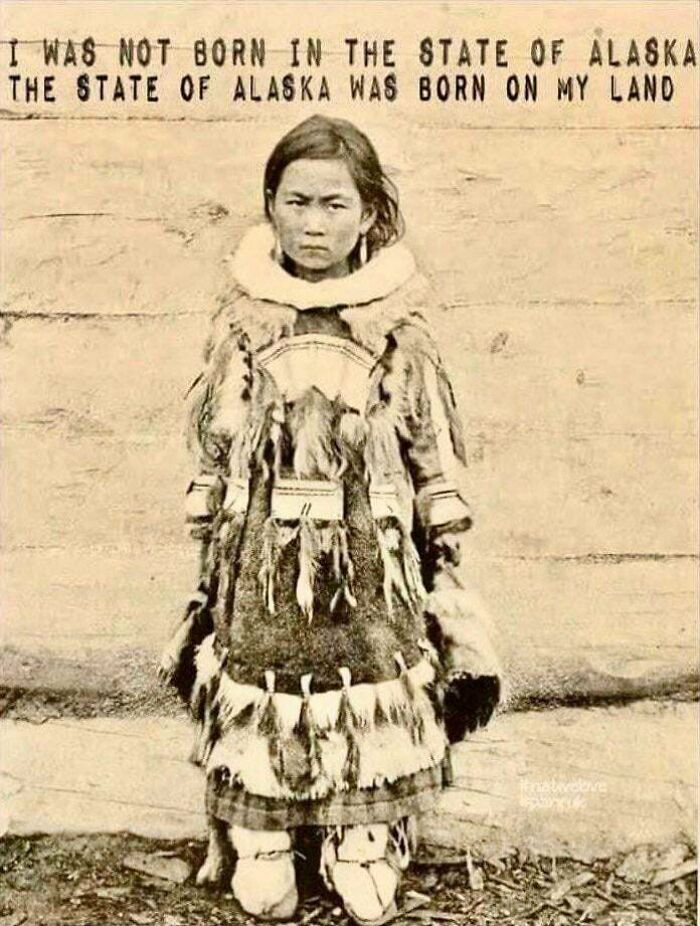 A young Native Alaskan child in traditional fur clothing, a fascinating photo from American history.