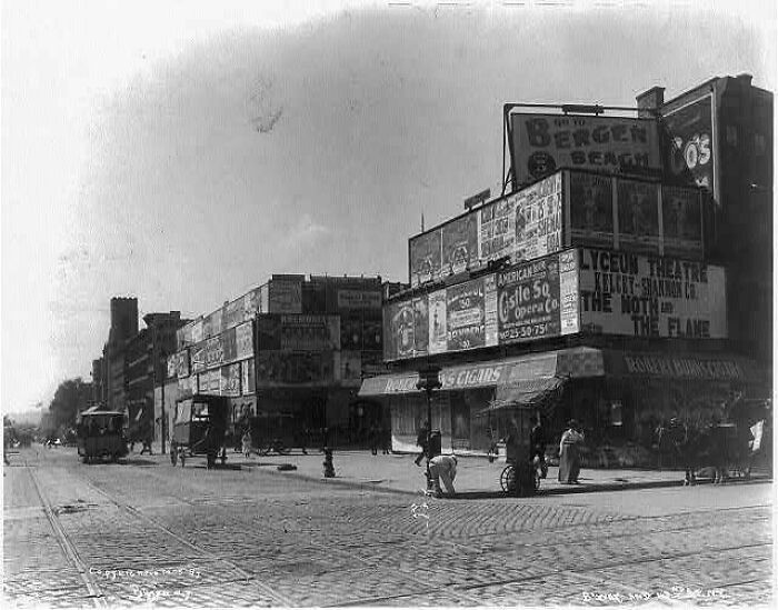 A busy New York City street with numerous buildings and advertisements, a fascinating American history photo.