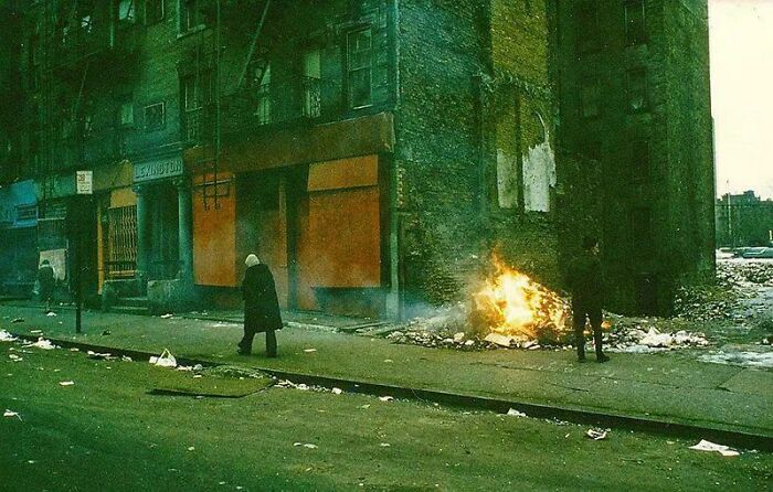 A fascinating photo from American history shows a desolate street scene with a fire burning, discarded trash, and two figures.