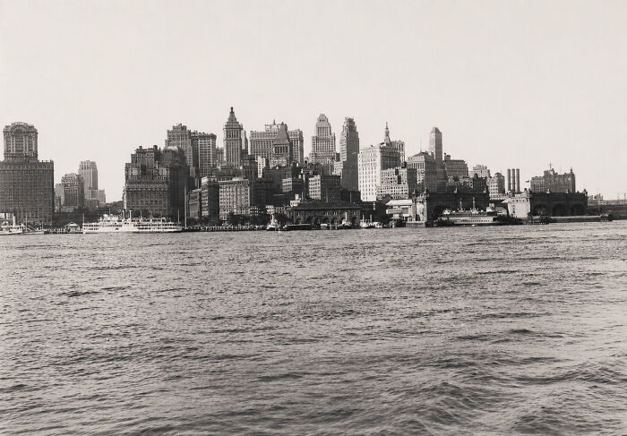 A fascinating photo from American history shows a panoramic view of a bustling city skyline from across a body of water.